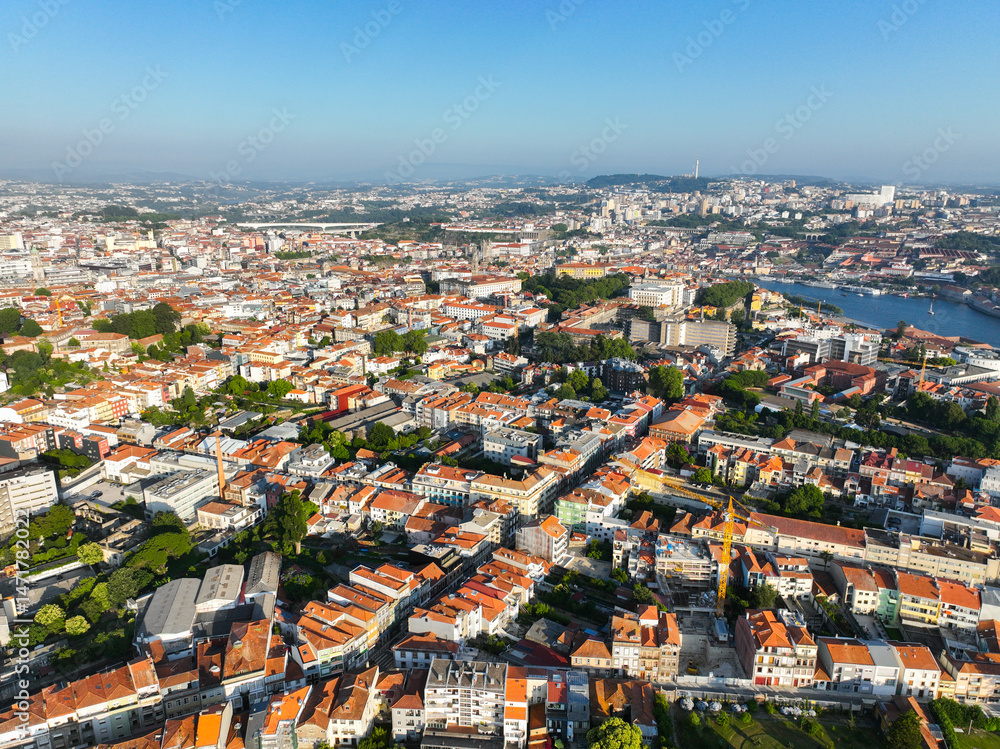 Obraz premium Wide aerial view of Porto, Portugal with dense rooftops, parks, and historic city blocks