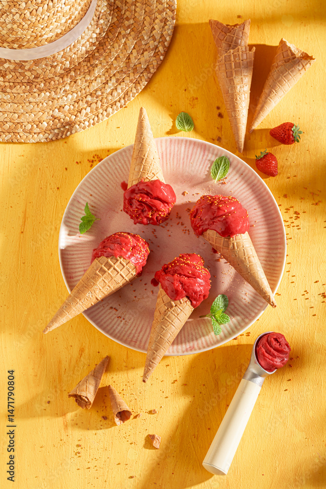 Sweet and cold strawberry ice cream in a waffle cone.