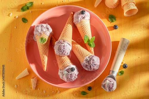 Obraz na płótnie Cold and sweet blueberry ice cream in a waffle cone. w salonie