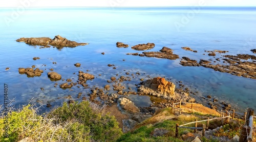 Serene coastal landscape with clear water and rocky shoreline  