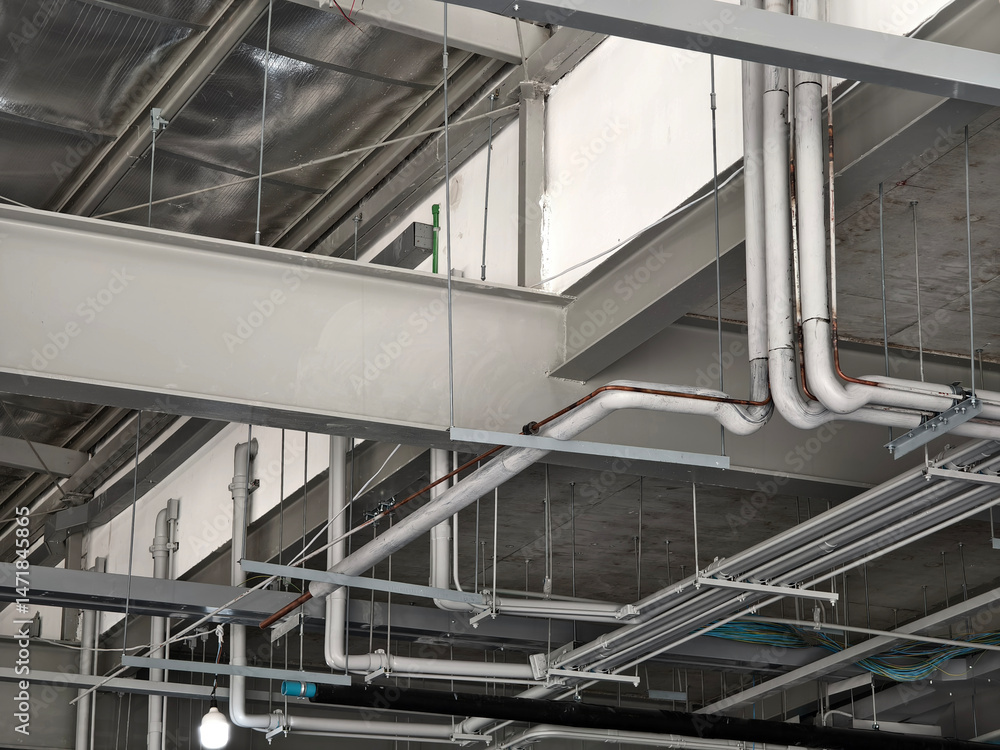 Naklejka premium The ceiling of a large building under construction an extensive network of pipes