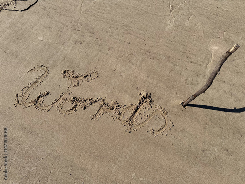in a sandy beach the word  words is written with a stick