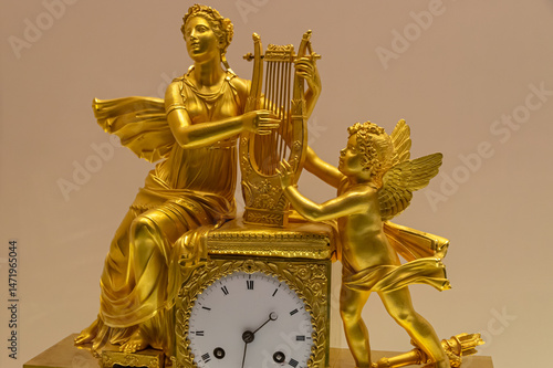 Bild auf Leinwand A muse with a harp in her hands and a little angel decorate an antique gold watch