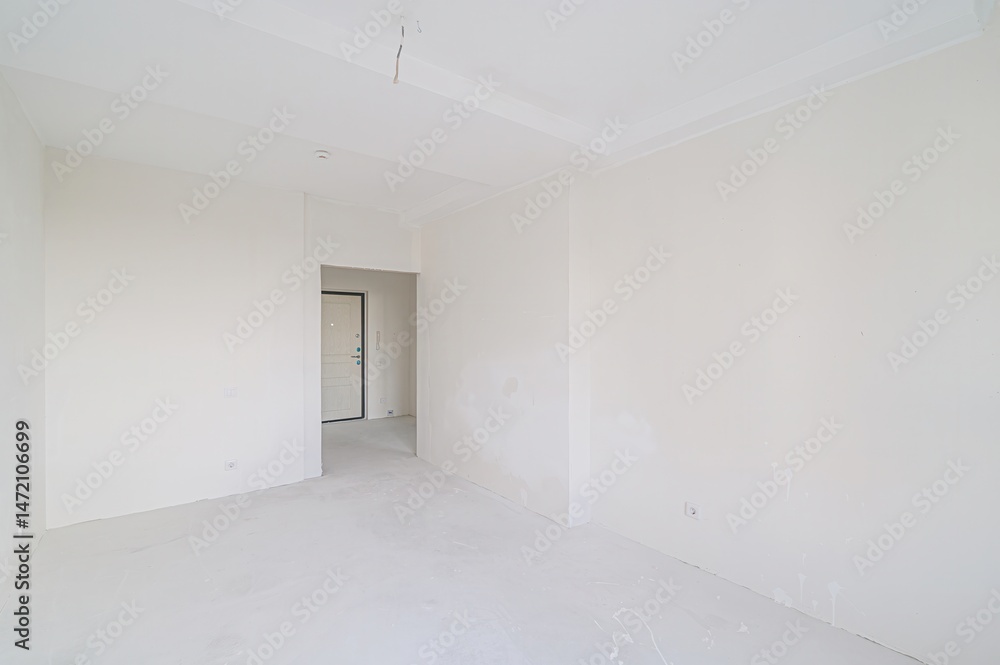 empty, all-white room with a doorway leading to another space. The walls are plain, and the floor is bare. Minimalist and clean aesthetic. empty, all-white room with a doorway leading to another space. The walls are plain, and the floor is bare. Minimalist and clean aesthetic.
