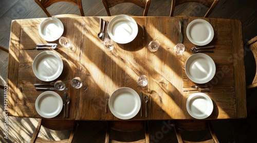Wooden dining table with empty chairs and place setting