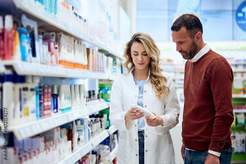 Fotografie Pharmacist Assisting Customer in Selecting Healthcare Products in Pharmacy Aisle