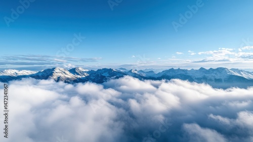 Majestic snow-capped mountain range peaking above a sea of clouds under a vibrant blue sky, offering a breathtaking panoramic view. : Generative AI