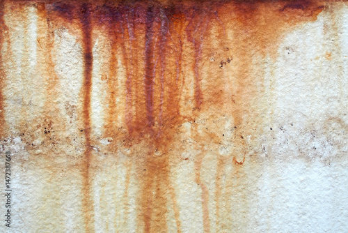dirty traces of rust stains flowing on concrete wall