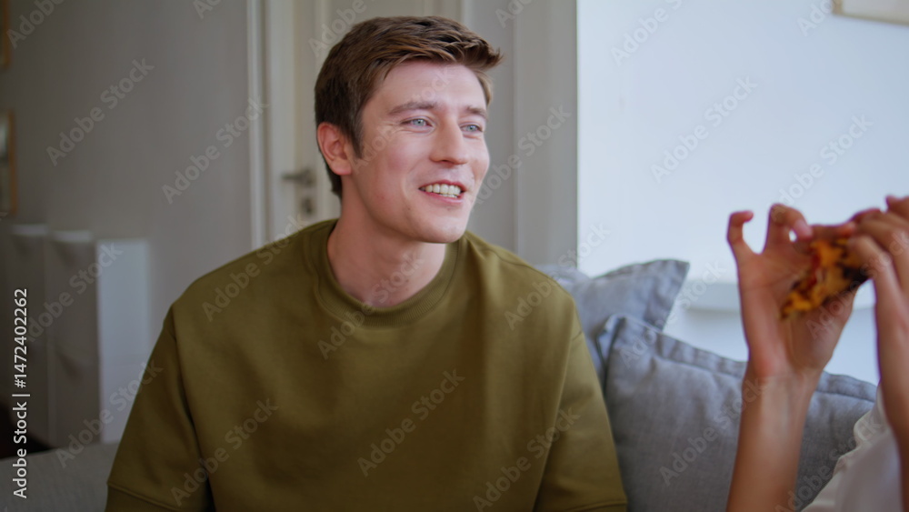 Cheerful guy talking girlfriend at domestic atmosphere closeup. Pair eating