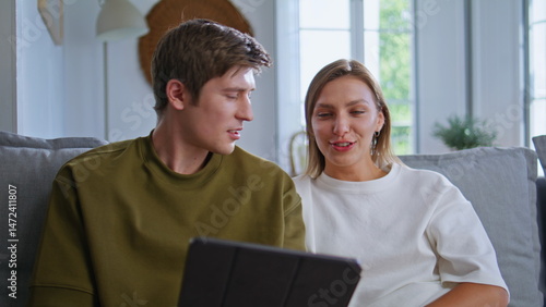 Obraz na płótnie Happy soulmates talking tab call living room closeup. Teen couple video calling w salonie