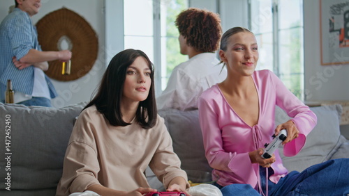 Video gamers have fun playing together home meeting closeup. Girls competition