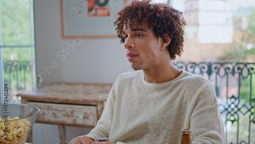 Obraz na płótnie Curly guy eating popcorn enjoying board game closeup. Students chilling together w salonie