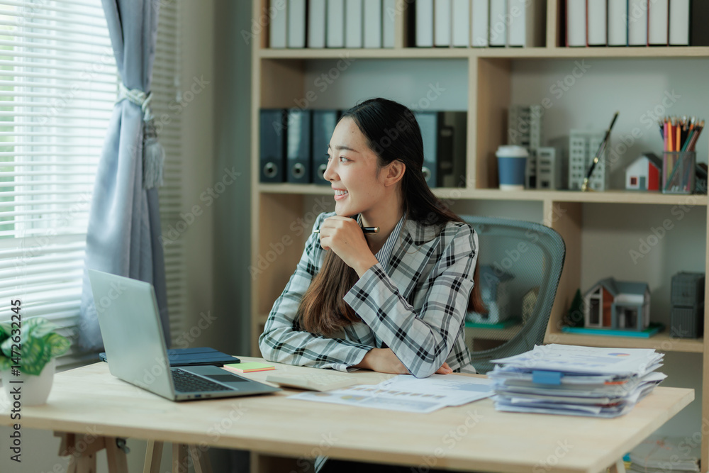 Professional female accountant reviewing annual expense reports at her desk with a laptop and paperwork — ideal for finance, tax, and corporate business themes. Professional female accountant reviewing annual expense reports at her desk with a laptop and paperwork — ideal for finance, tax, and corporate business themes.