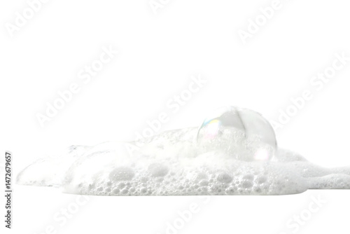 Closeup of a single iridescent soap bubble nestled in a pile of fluffy white foam
