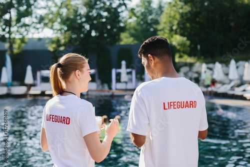 Lifeguards supervising swimming pool on sunny day