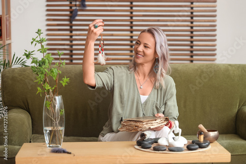 Woman with dream catcher and old book at home