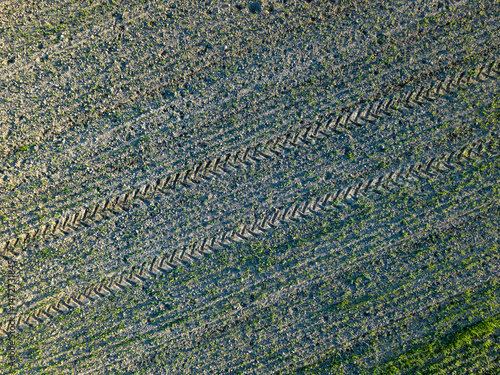 Tractor tracks visible on a field in the countryside, aerial view