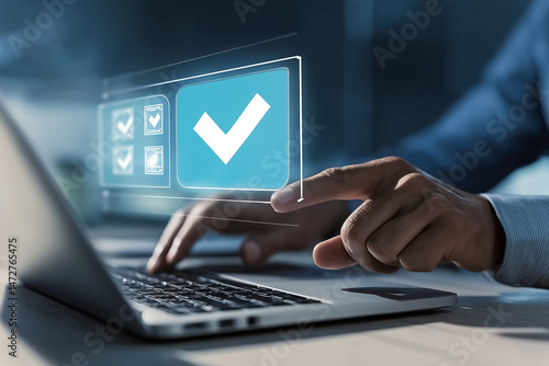 Hand interacting with digital blue checkmark icon on floating interface above laptop keyboard
