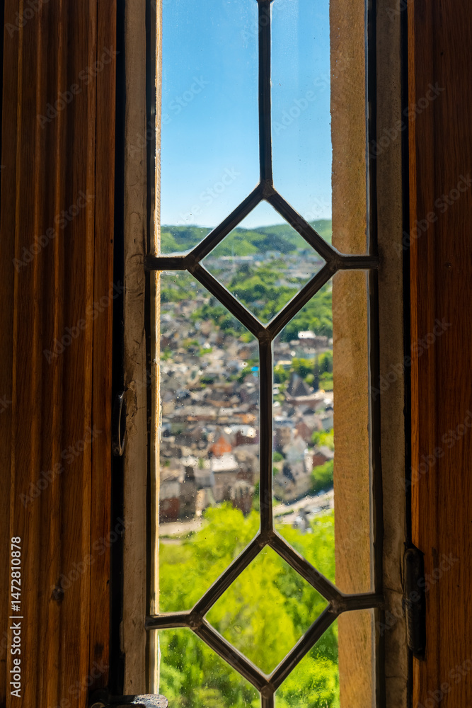 Fototapeta premium View from an ancient window overlooking a charming hillside village on a bright sunny day