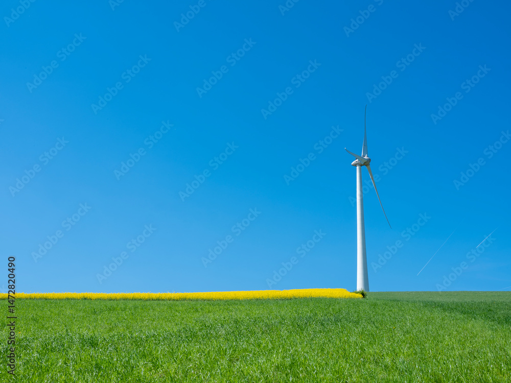 countryside landscape in luxemburg with wind turbine under blue sky in spring