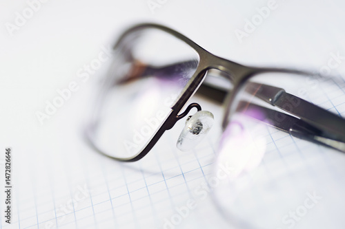 glasses lying on a sheet of checkered paper