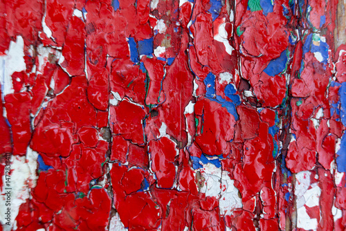 Colorful peeling paint reveals texture and age on a wooden surface