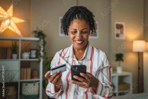african american woman use credit card and cellphone for shopping