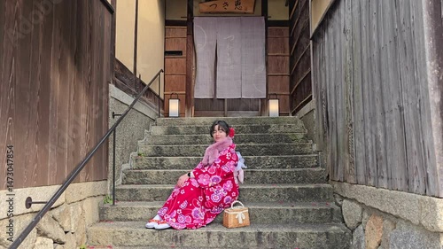 A pretty girl in a kimono. Kimono is the traditional dress worn popular in Japan. American girl posing in kimono outdoors. 