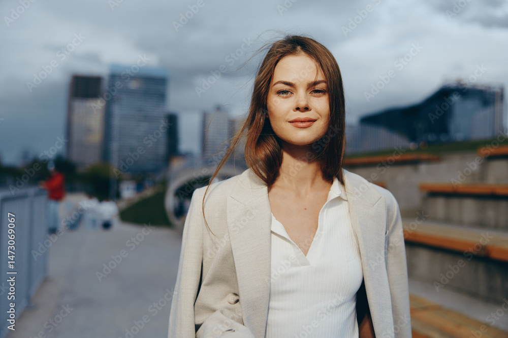 Fototapeta premium confident woman in business casual wear smiling outdoors with city buildings in background in urban fashion style