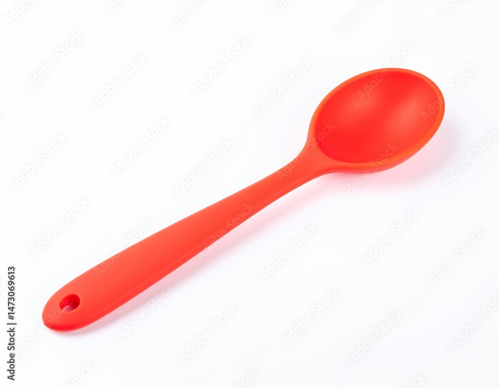 Red cooking utensil; rounded spoon with small hole on handle end, placed atop white surface Red cooking utensil; rounded spoon with small hole on handle end, placed atop white surface
