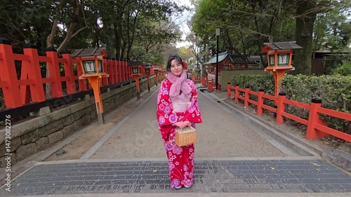 A pretty girl in a kimono. Kimono is the traditional dress worn popular in Japan. American girl posing in kimono outdoors. 