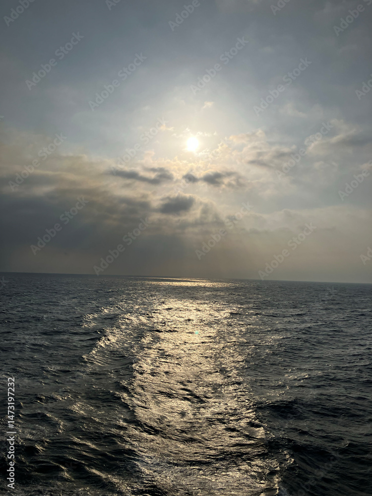 Obraz premium 海から見る雲と登る太陽