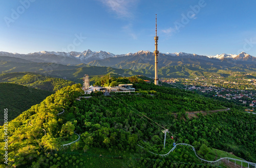 Mount Kok Tobe (Blue Hill) with the famous TV tower against the backdrop of the Zailiyskiy Alatau mountain range in the Kazakh city of Almaty on an early spring morning photo