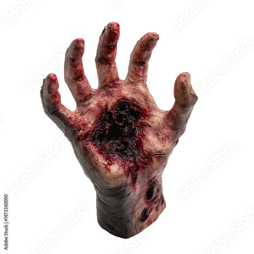 A gory hand prop from a horror movie scene. The hand appears injured and covered in blood