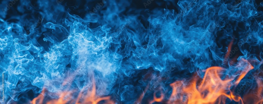 Fototapeta premium A vibrant blend of blue smoke and orange flames, creating a striking contrast against a dark background.