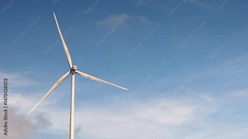 Wind Turbines Spinning Under Clear Blue Sky – Renewable Energy Concept. Aerial View of Wind Turbines on Green Field with Blue Sky – Clean Energy Wind Turbines Spinning Under Clear Blue Sky – Renewable Energy Concept. Aerial View of Wind Turbines on Green Field with Blue Sky – Clean Energy
