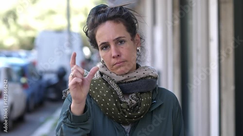 A brunette woman expresses with her fingers that something is minimal or insignificant, slightly amused by its size