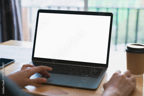 Businessman hand typing on laptop and working on computer on wooden table, screen blank mockup.