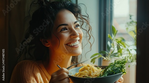 Obraz na płótnie A smiling woman with long, wavy hair holds a wooden bowl filled with salad, while a spoon is poised near her mouth. w salonie