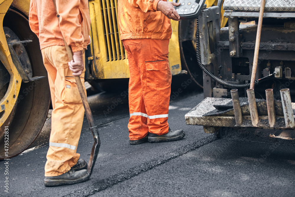 Construction workers working on a new asphalt layer on a public street. Construction workers working on a new asphalt layer on a public street.