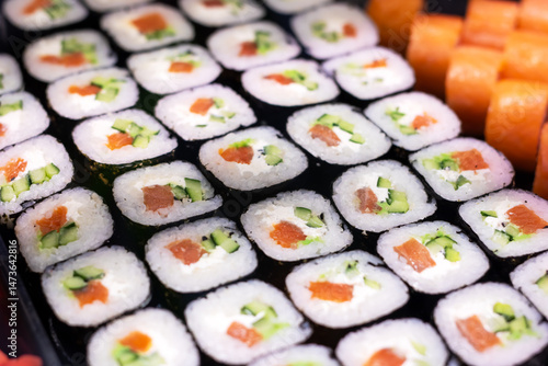 A delightful bunch of sushi rolls are neatly lined up on a table