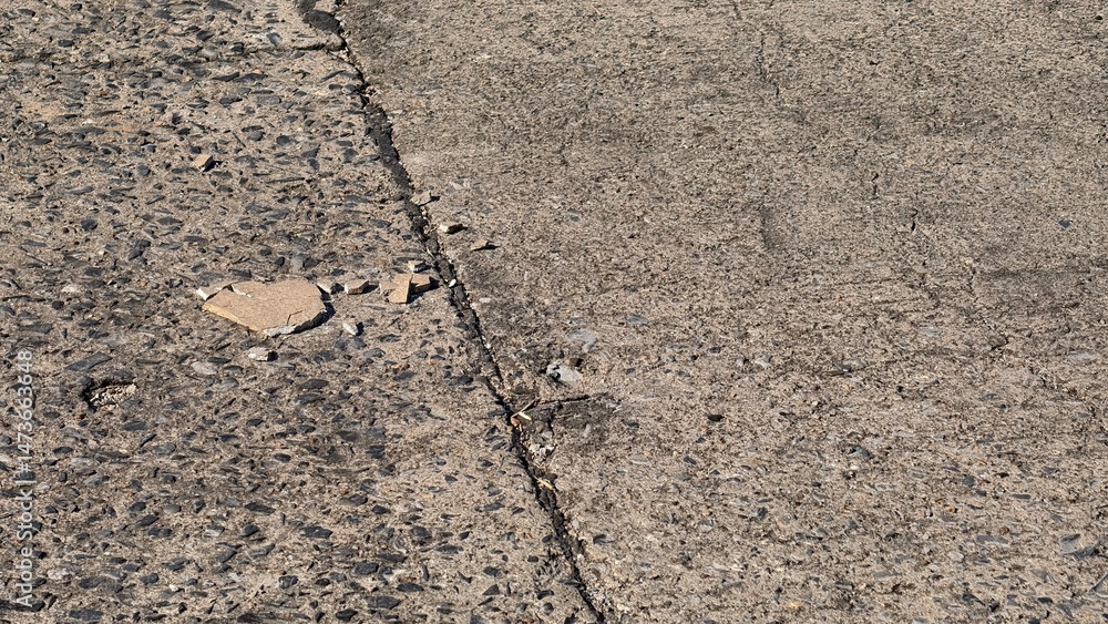 Fototapeta premium Close-Up View of Cracked and Chipped Concrete Surface with Texture and Grain Detail