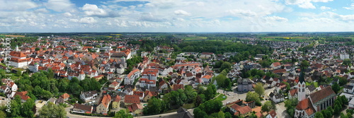 Eine beeindruckende Luftaufnahme von Günzburg, einer charmanten Stadt in Bayern. Die Stadt ist geprägt von einer harmonischen Mischung aus historischen und modernen Gebäuden mit roten Ziegeldächern.