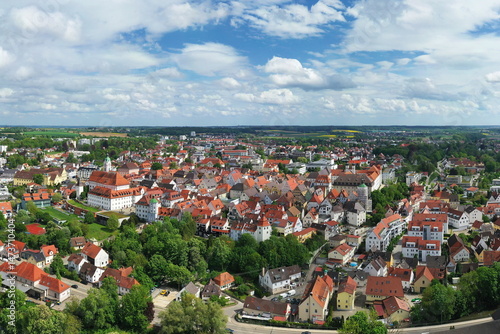 Eine beeindruckende Luftaufnahme von Günzburg, einer charmanten Stadt in Bayern. Die Stadt ist geprägt von einer harmonischen Mischung aus historischen und modernen Gebäuden mit roten Ziegeldächern.