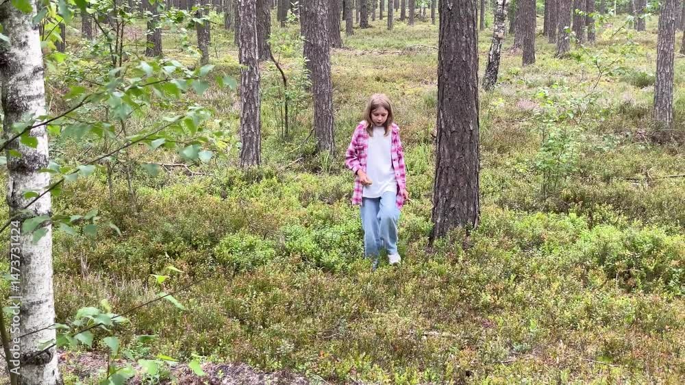 Girl picking berries in a forest Girl picking berries in a forest