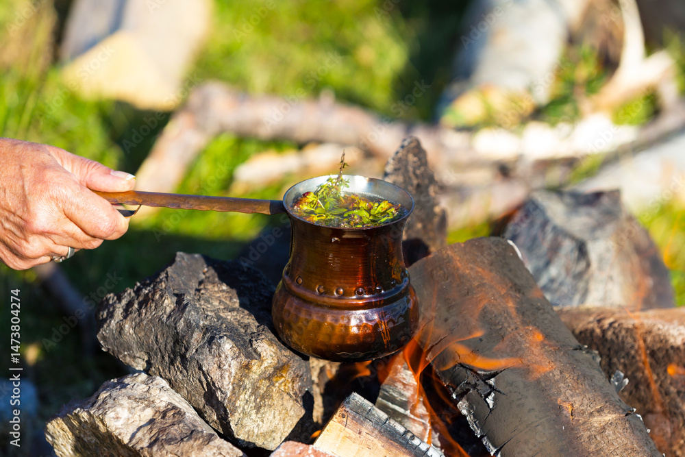 Making herbal tea in cezve on campfire