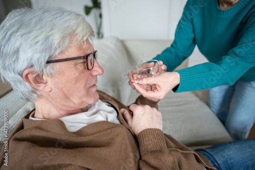 Struggling sad pensioner taking pills from wife hand before fall. Chest gripping, urgent medical need, aging failure issues, spousal support, drug prescription, cardiac collapse, high pressure