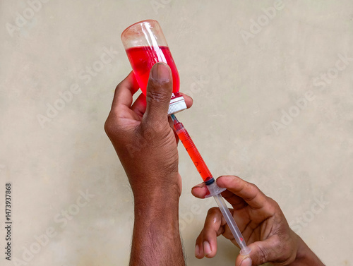 injection and red liquid in a bottle