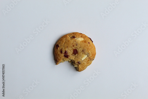 A bitten white choco soft cookie with almond and berry cuts, isolated on white background