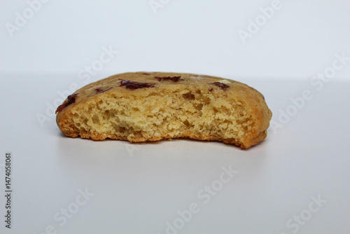 A bitten white choco soft cookie with almond and berry cuts, isolated on white background